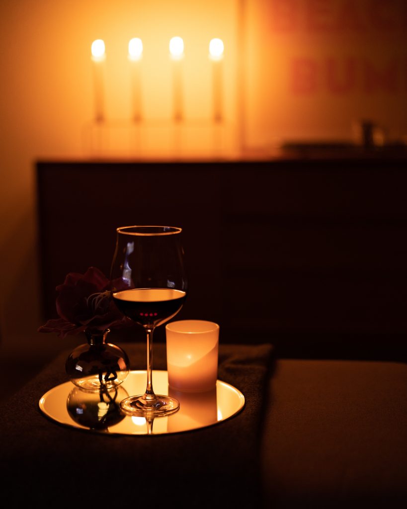 candle in dark living room with wine